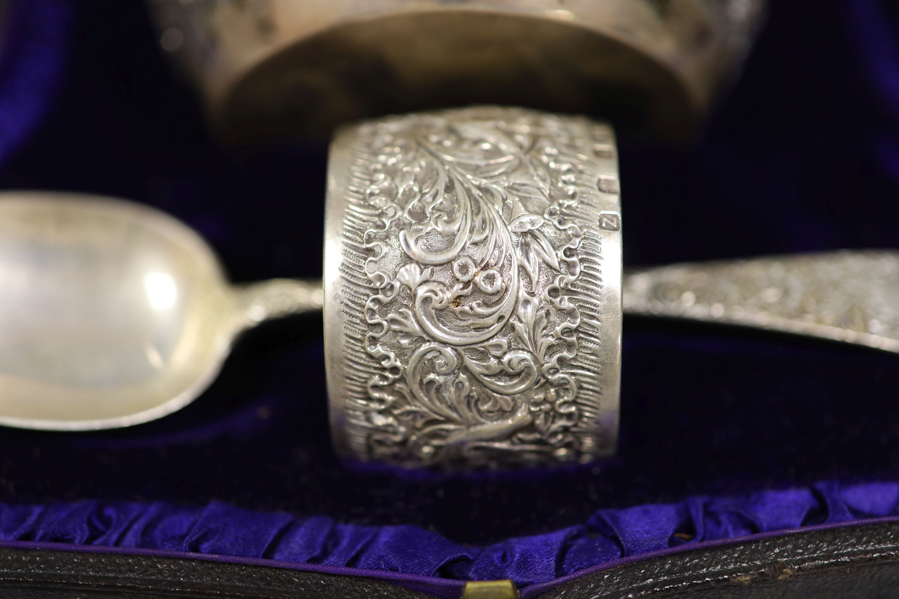 A cased late Victorian embossed silver christening bowl, spoon and napkin ring, Aird & Thomson, Glasgow, 1896, bowl 10.7cm, 7.5oz.